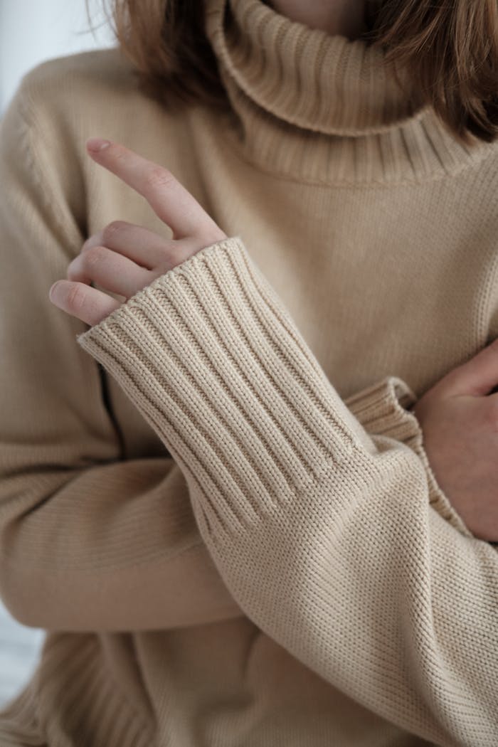 Woman in sweater crossing arms on chest